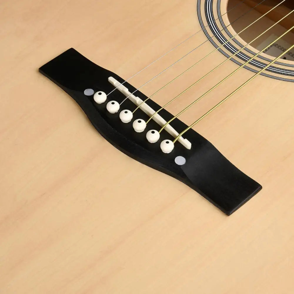 Close-up of bridge and strings on Axiom Folkmaster Left Handed Guitar Natural, perfect for beginner guitar left hand players in Australia