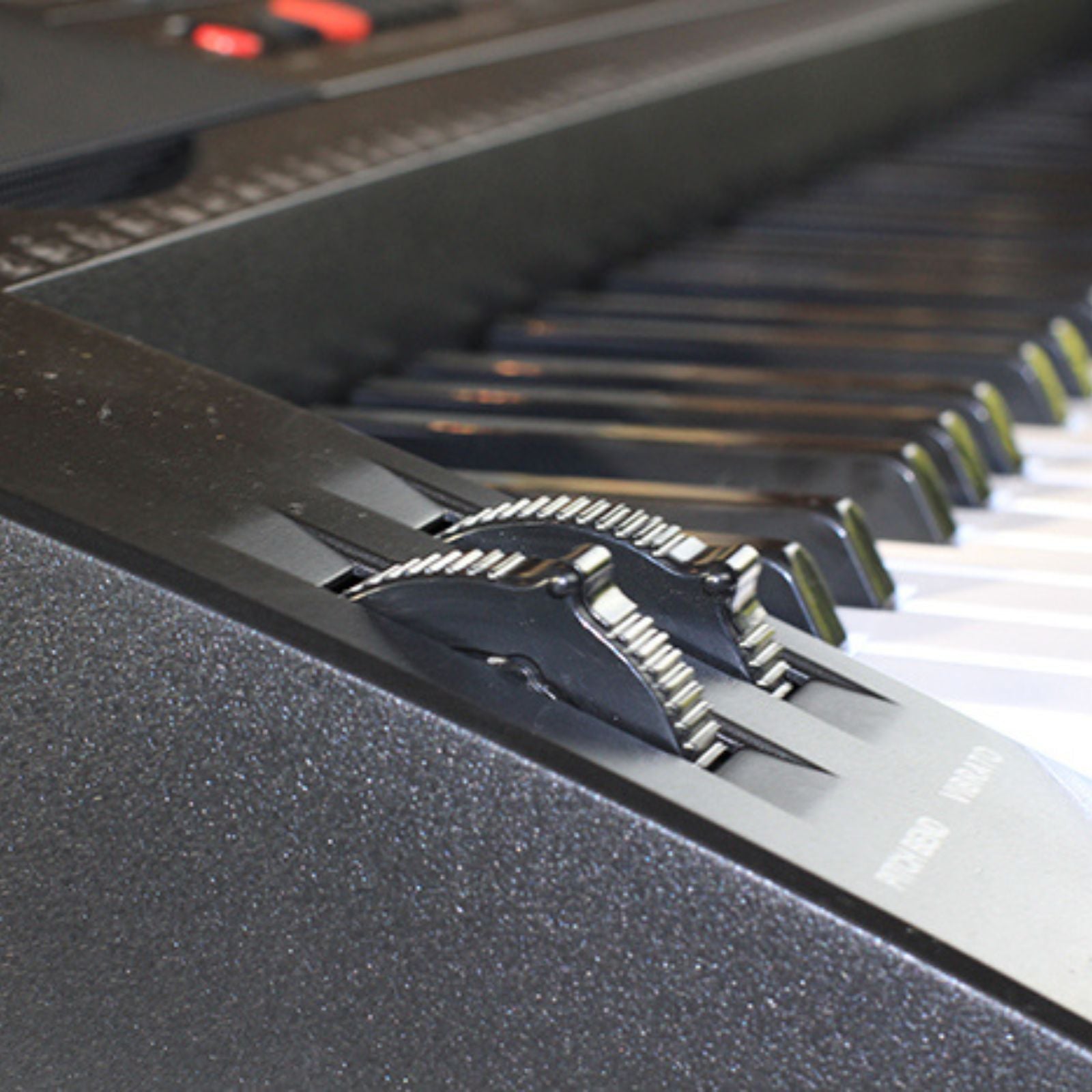 The Axiom Student Beginner Keyboard with Touch Response by Axiom Music features 61 white and black keys, control buttons, speakers, a sheet music stand, and intelligent teaching functions.
