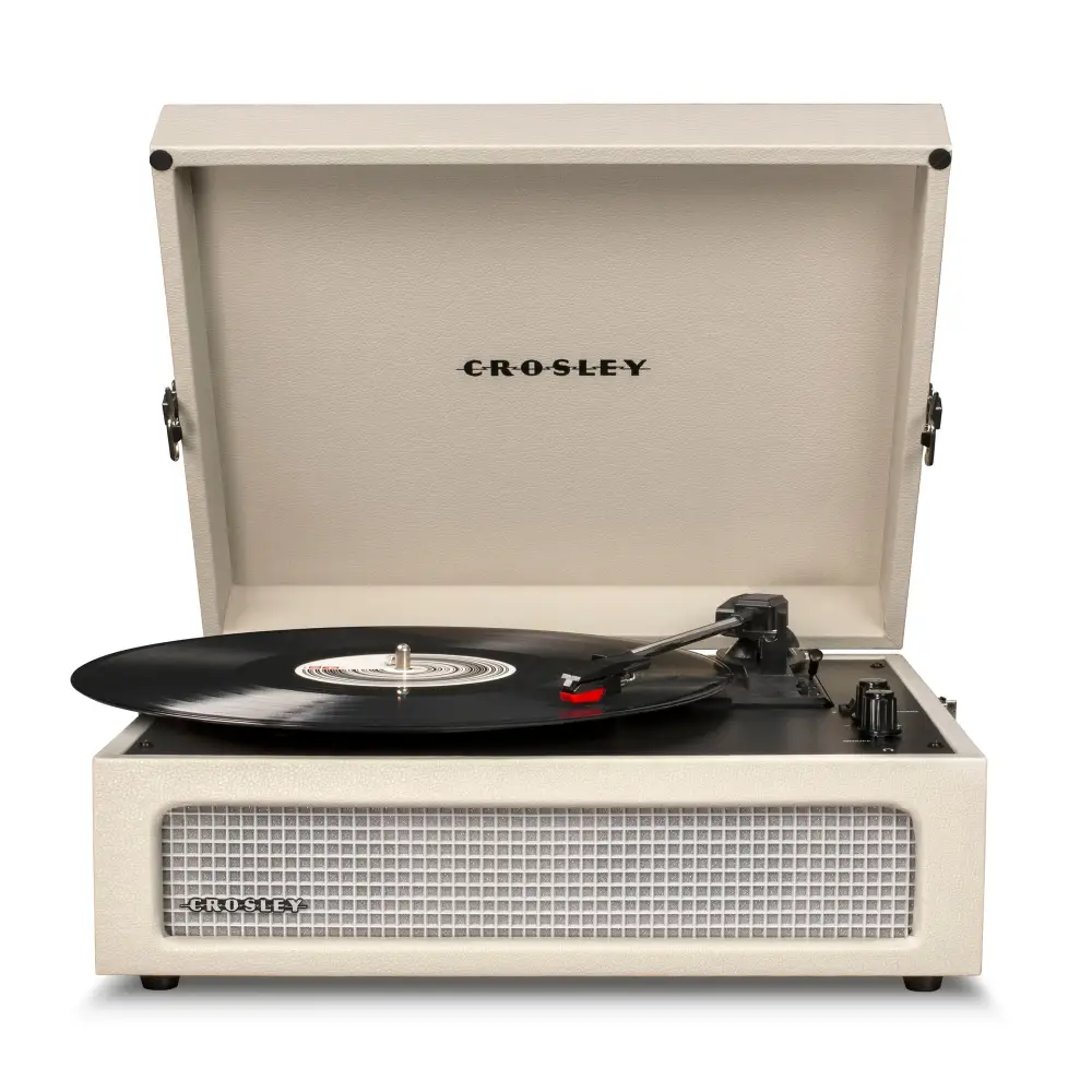 Cream-colored Crosley Voyager Dune Bluetooth portable turntable with black vinyl record