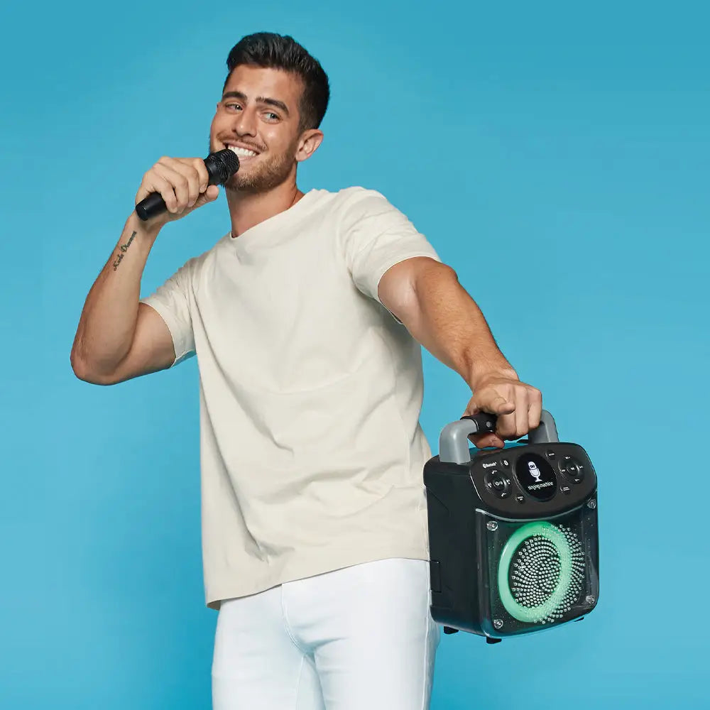 Man holding microphone and portable Singing Machine Mini Sparkle Bluetooth Karaoke Speaker