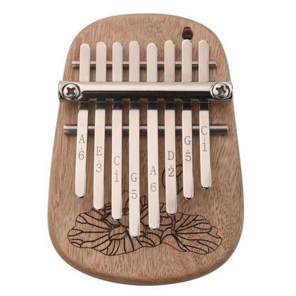 The Axiom Kalimba Thumb Piano by Axiom Music is crafted from camphor wood with an engraved floral design, labeled metal tines for notes and numbers, and comes with a tuning hammer for easy adjustments.