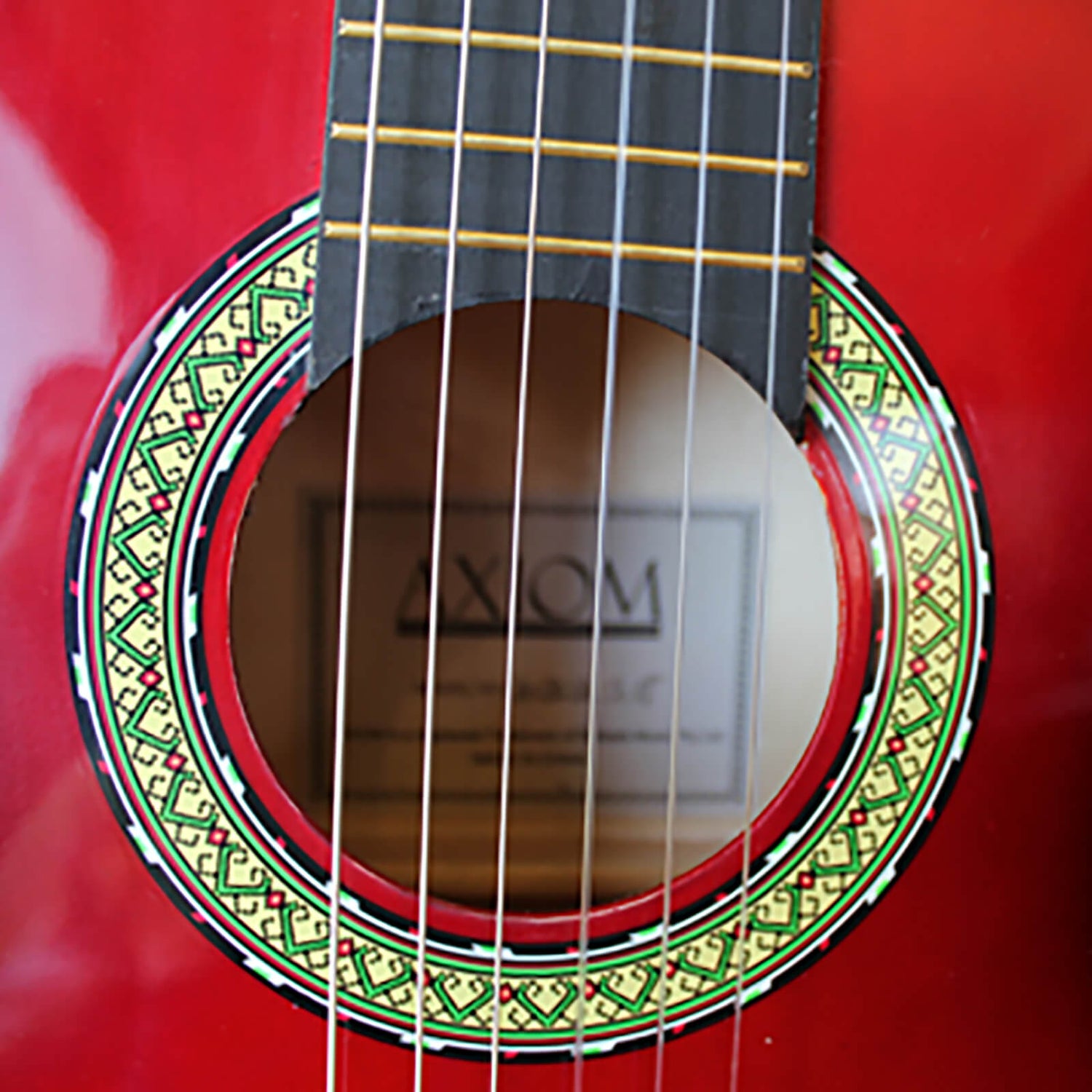 The Axiom Childrens Guitar Pack - 3/4 Size Red by Axiom Music features a red acoustic beginners guitar with nylon strings, black edge, stand, high quality tuners, extra strings, pick, and a black carrying case.