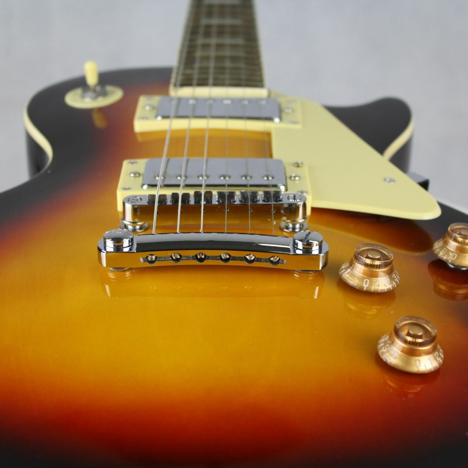 The Axiom Challenger Electric Guitar - Sunburst by Axiom Music features a single cutaway, vintage-style humbuckers, white pickguard, four control knobs, and a rosewood fretboard with block inlays.