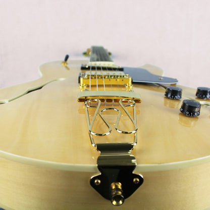 The Axiom Music Columbia Archtop Electric Guitar - Natural features a hollow body, black and gold hardware, f-hole, rectangular fretboard inlays, and vintage-style humbuckers.