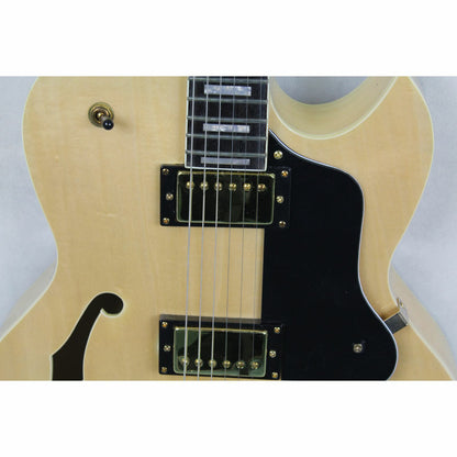 The Axiom Music Columbia Archtop Electric Guitar - Natural features a hollow body, black and gold hardware, f-hole, rectangular fretboard inlays, and vintage-style humbuckers.
